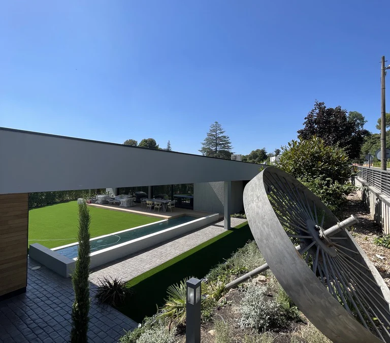 Diseño de jardín moderno con césped, piscina y paisajismo realizado por Serveis Jardineria Soler