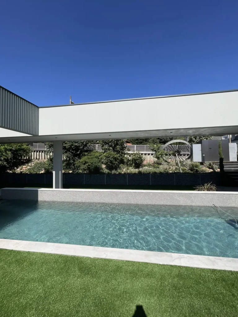 Jardín con piscina y césped artificial instalado por Serveis Jardineria Soler