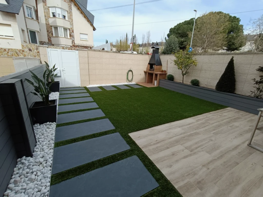 Jardín moderno con vallas de ocultación de composite, césped artificial y pavimento porcelánico