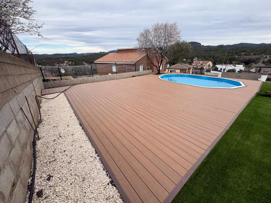 Tarima sintética instalada junto a una piscina durante una reforma integral de jardín