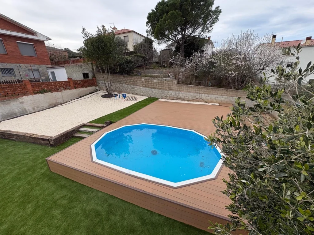 Tarima sintética instalada alrededor de una piscina en un jardín residencial de Terrassa