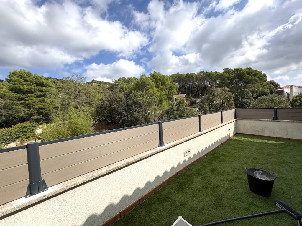 Valla de ocultación de composite beige instalada en un jardín residencial para ganar privacidad